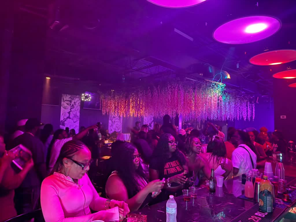 Guests gathering at the bar inside Gossip Lounge